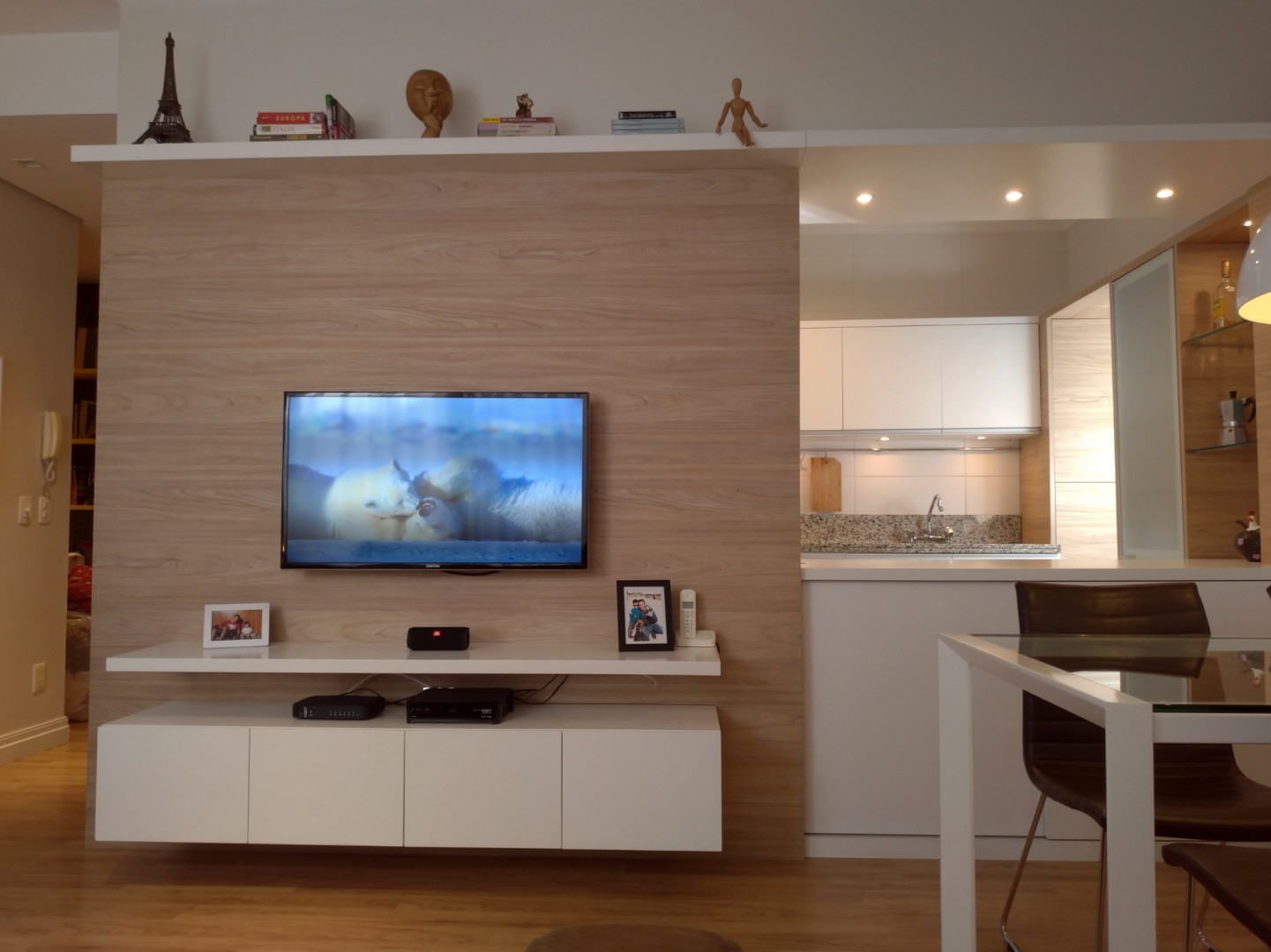 CUBIK Arquitetura - integração entre cozinha e sala feita por vão aberto na parede. TV no painel e prateleira superior. Pé-direito alto decoração design e arquitetura de interiores 